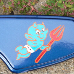 A blue eyeglass case with a devil on it.