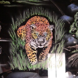 A painting of a jaguar on the side of a car.