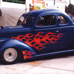 A blue car with flames on it.