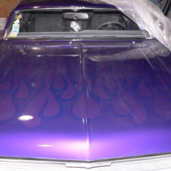 A purple car with flames on the hood.