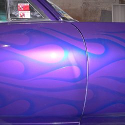 A purple car with flames painted on it.