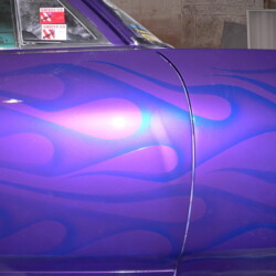 A purple car with flames painted on it.