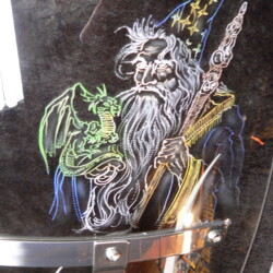 A picture of a wizard holding a sword and a dragon.