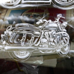 A motorcycle is reflected in a window.