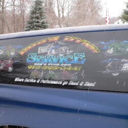 A blue car is parked in the snow.