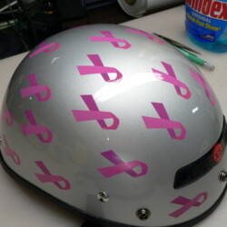 A helmet with pink ribbons on it.