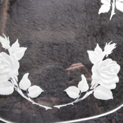 A glass plate with white roses on it.