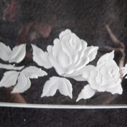 A glass plate with a white flower design.