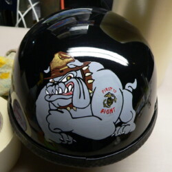 A black motorcycle helmet with a bulldog on it.