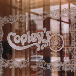A glass door with the word copley's on it.