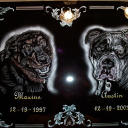 A black and silver plaque with two dogs on it.