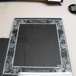 A glass frame with a name on it sitting on a table.