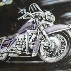 A purple and silver motorcycle painted on a black wall.