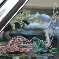 A car window with a drawing of a woman laying on the ground.