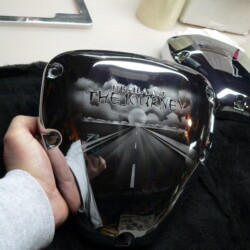 A person holding a motorcycle cover with a picture of a road on it.