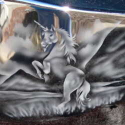 A unicorn painted on the side of a car.