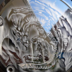 A silver plate with a picture of a dragon on it.
