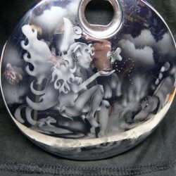 A black bag with a silver pendant on it.