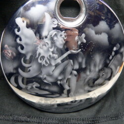 A black bag with a silver pendant on it.