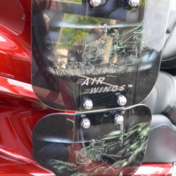 A close up of a red motorcycle with a shield on it.