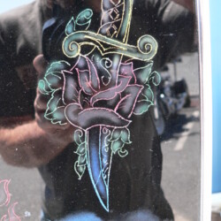 A man with a tattoo of a rose and a sword.