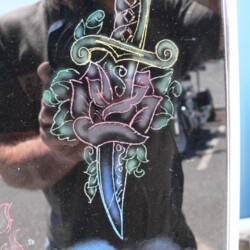 A man with a tattoo of a rose and a sword.