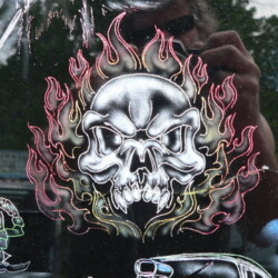A picture of a car with a skull and flames on it.