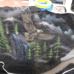 An eagle painted on the side of a windshield.