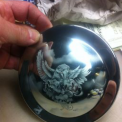 A person holding a silver plate with an eagle on it.