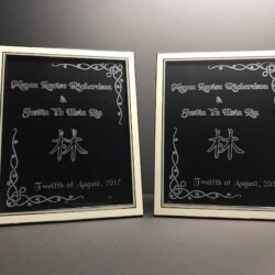 Two black framed plaques with chinese writing on them.