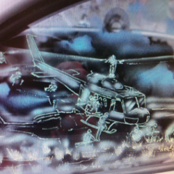 A picture of a helicopter in the window of a car.