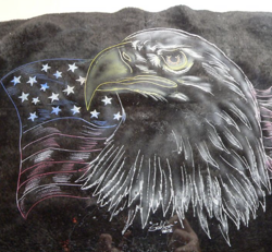 An eagle with an american flag on a black towel.