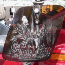 A motorcycle with a deer on the side of it.